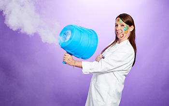 Mad scientist with face paint holding a toy bazooka type machine blowing smoke 